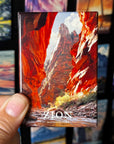 A hand holding a magnet with a colorful image of a canyon, specifically the Zion National Park.