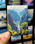 A hand holding a magnet with a picture of the Black Canyon of the Gunnison National Park.