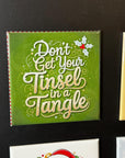 a green square magnet with a decorative text that reads "Don't Get Your Tinsel in a Tangle".