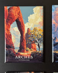 a collection of landscape magnets, including a prominent magnet with an illustration of a large arch formation surrounded by trees and a body of water.