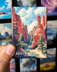 A hand holding a magnet depicting the scenic landscape of Bryce Canyon National Park.