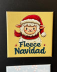A yellow square magnet with a cartoon image of a sheep wearing a Santa hat and scarf, along with the text "Fleece Navid" written below it.
