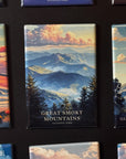 a collection of magnets depicting various scenic landscapes, including mountains, forests, and other natural elements. The magnets are arranged in a grid-like pattern, showcasing the beauty of these landscapes.