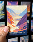 A hand holding a magnet with a colorful illustration of Death Valley National Park.