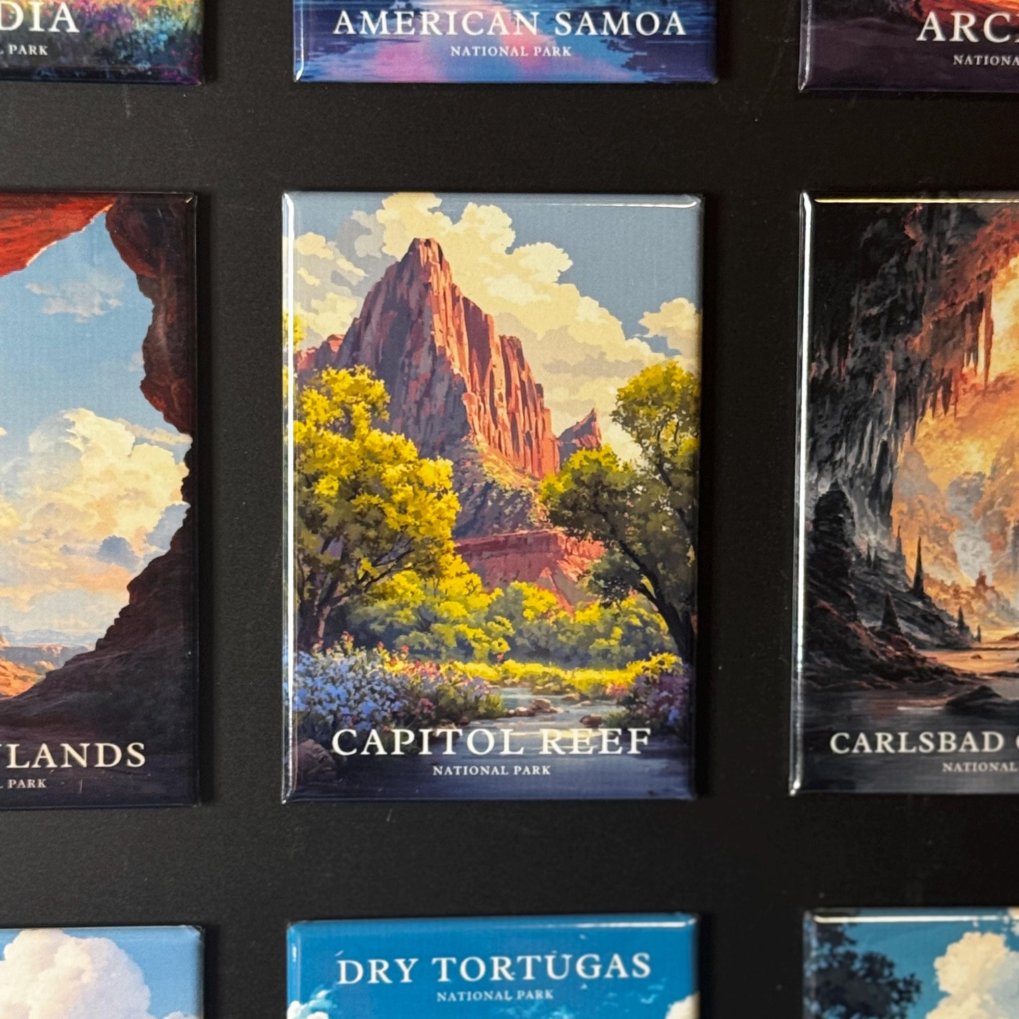 a collection of magnets depicting various landscapes, including mountains, forests, and bodies of water.