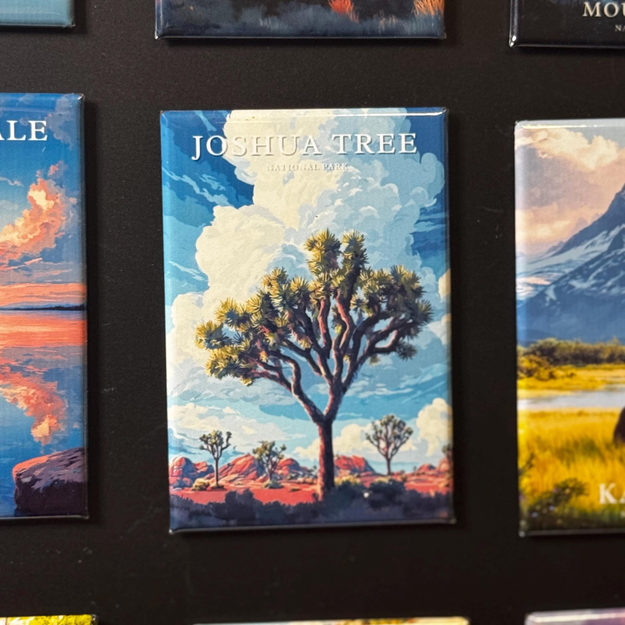 a large magnet with a painting of a Joshua tree in a desert landscape.