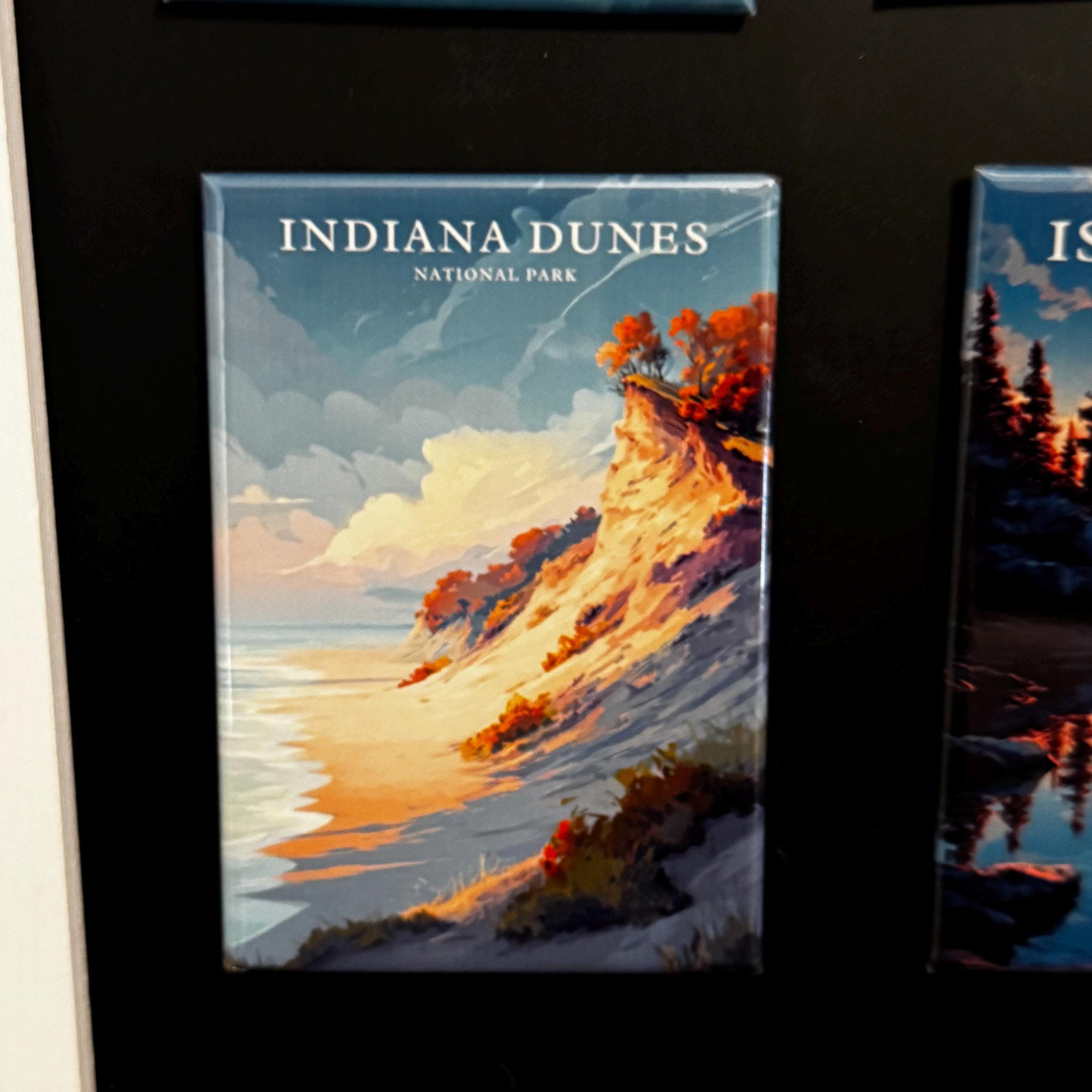 The image is a framed print of a scenic landscape depicting a cliff overlooking a beach and the ocean.