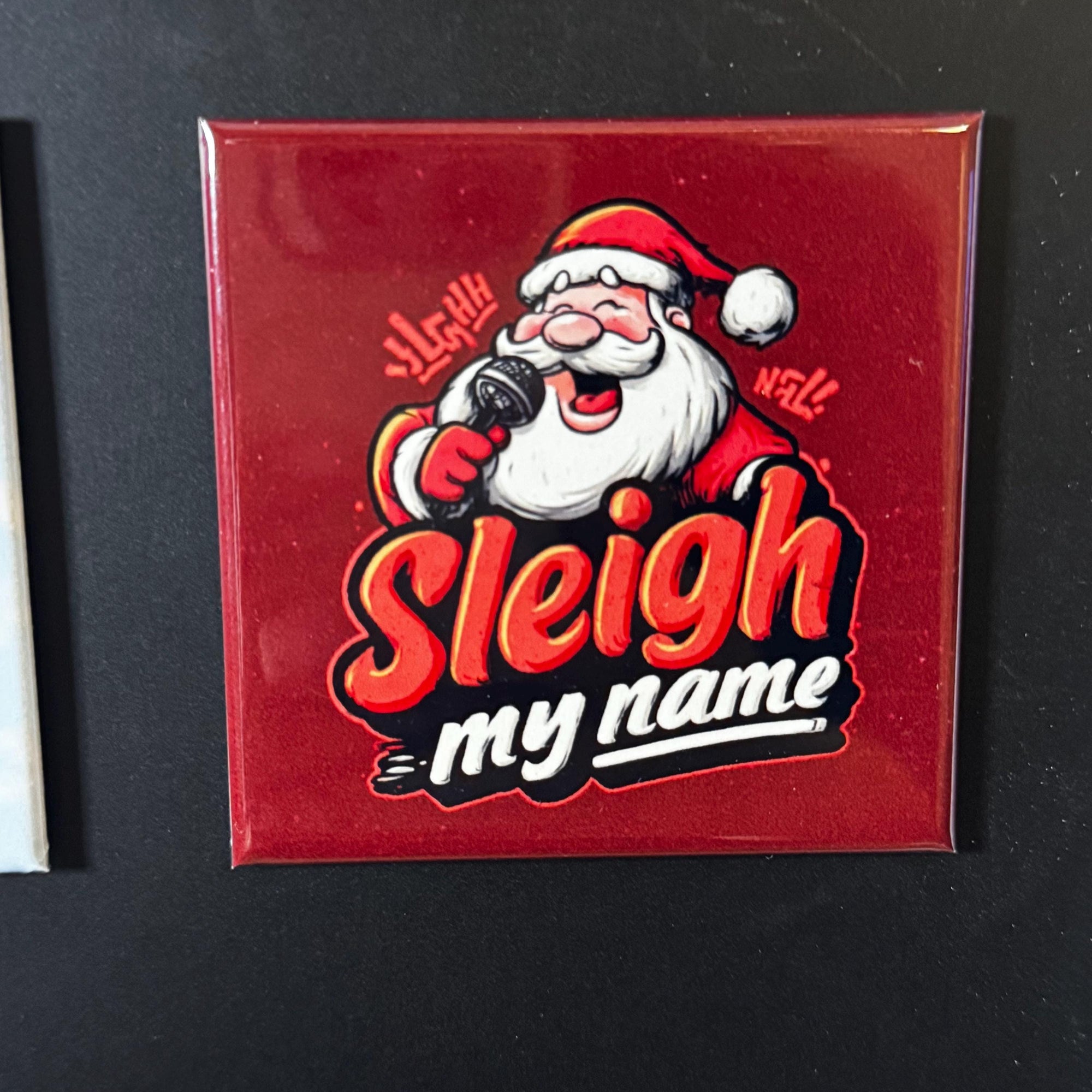 A red tile with a cartoon image of Santa Claus holding a microphone and singing, accompanied by the text "Sleigh my name".