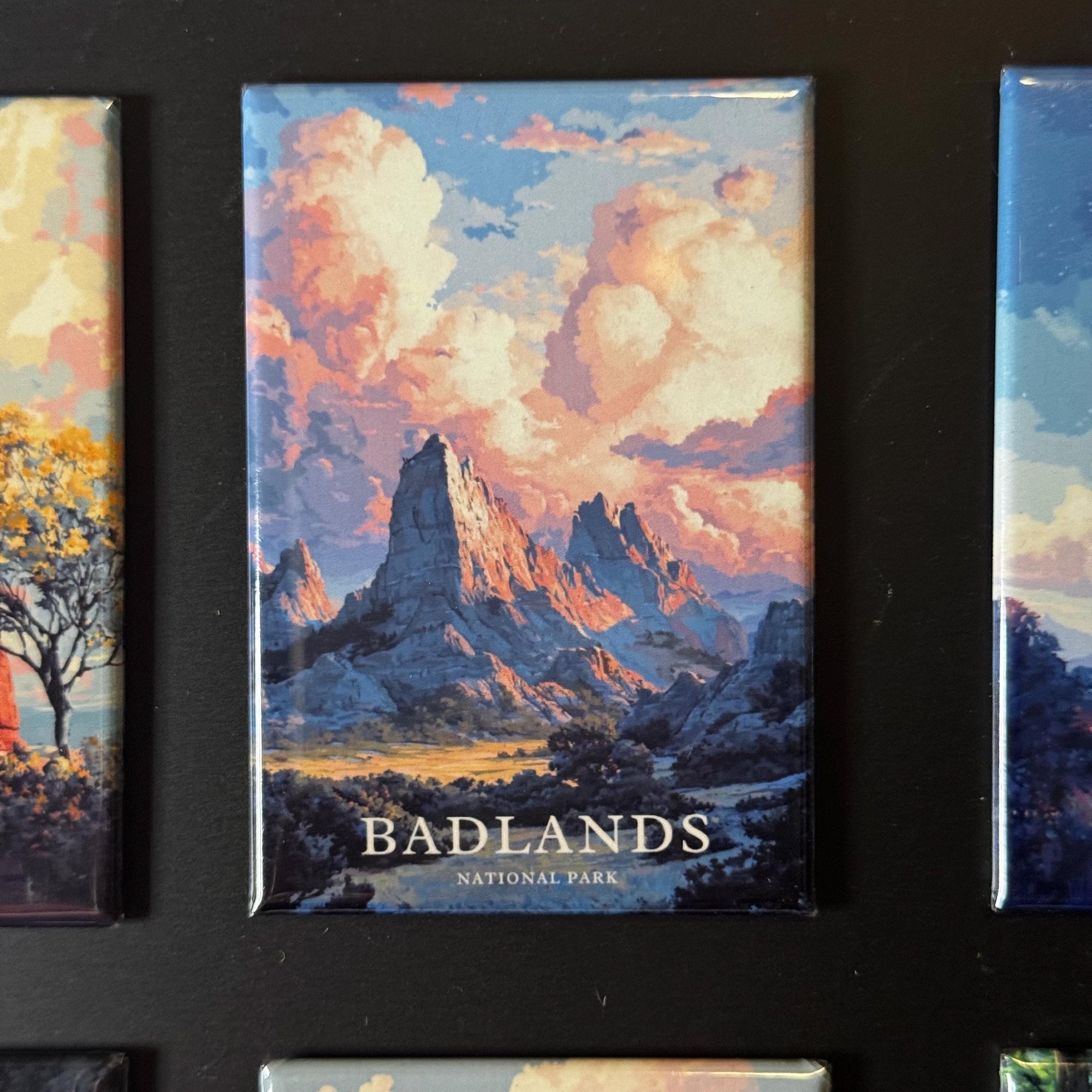 a large magnet with a painting of a mountainous landscape, depicting the Badlands National Park.