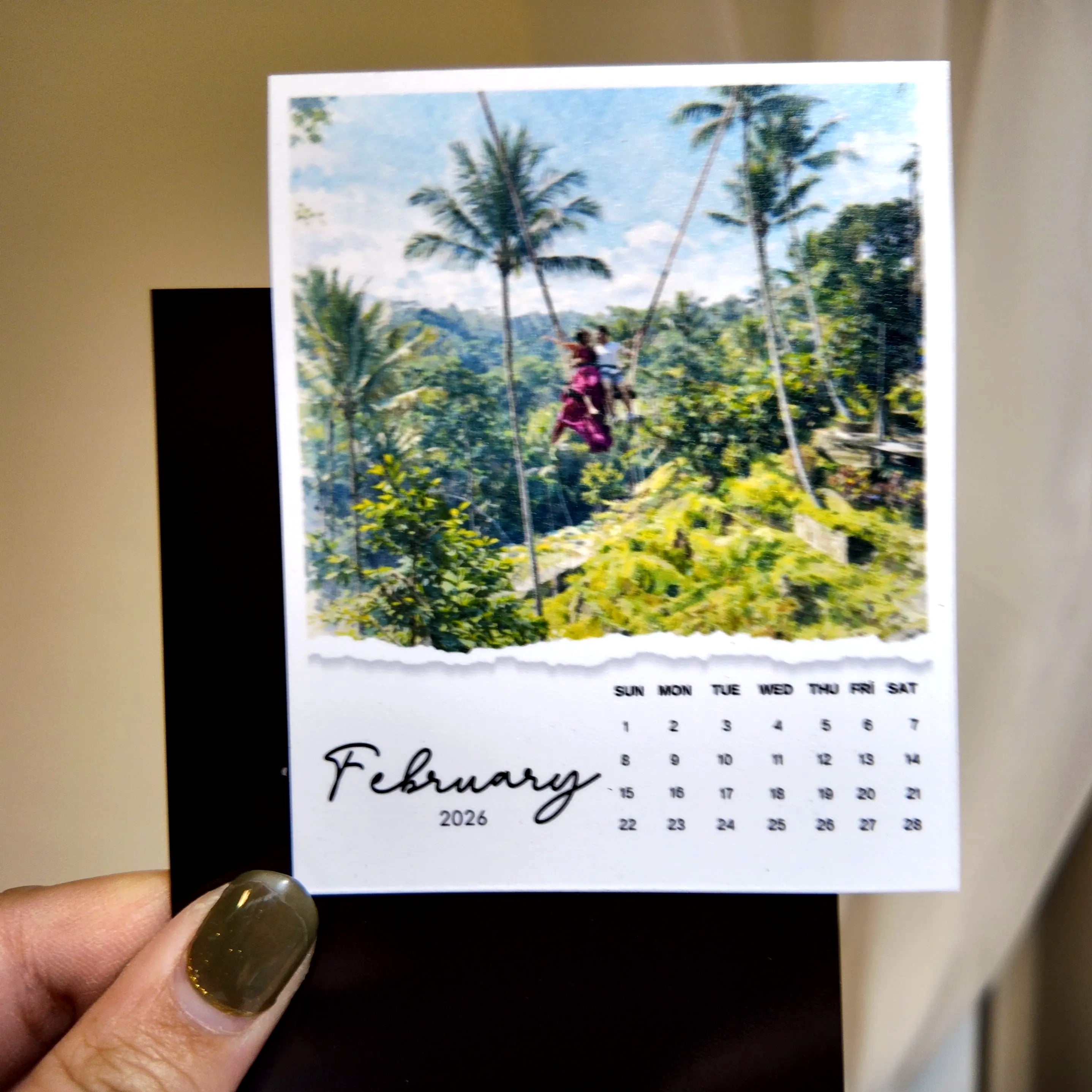 A person holding a calendar featuring a tropical beach scene with palm trees and a person in a red dress.