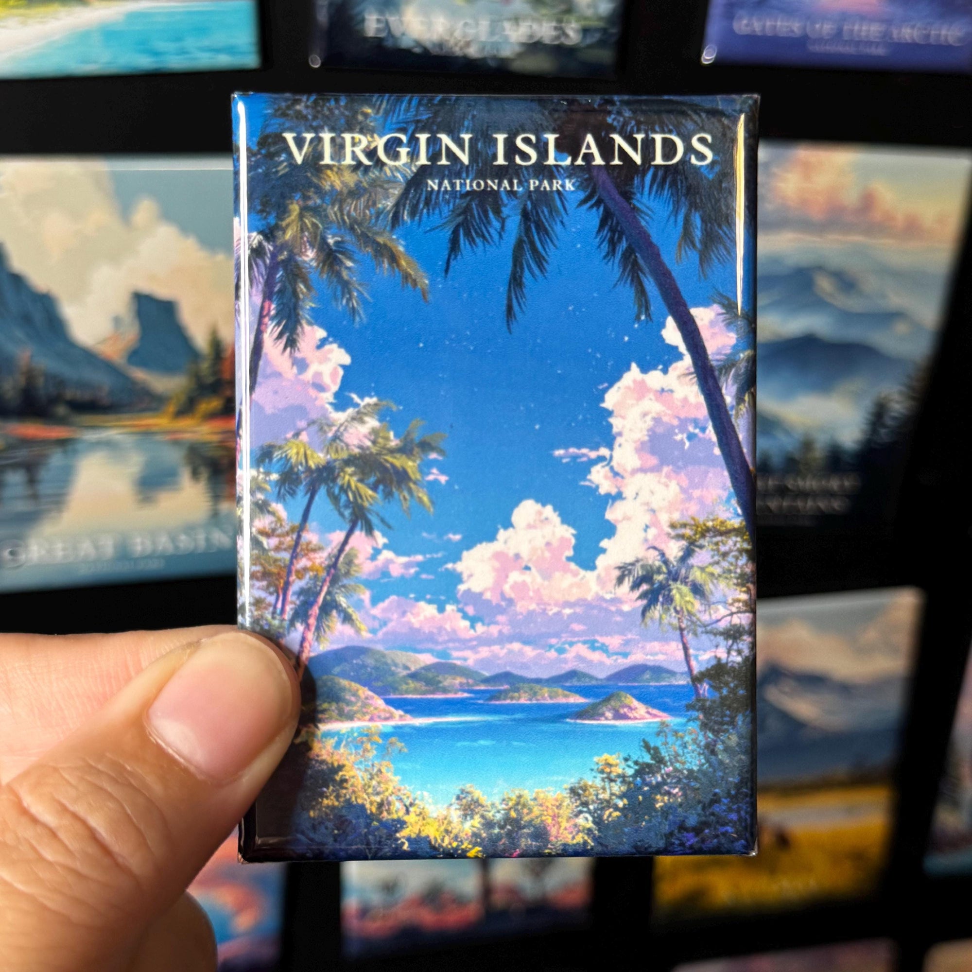 A hand holding a magnet with a tropical island landscape, including palm trees, a blue sky, and a body of water.