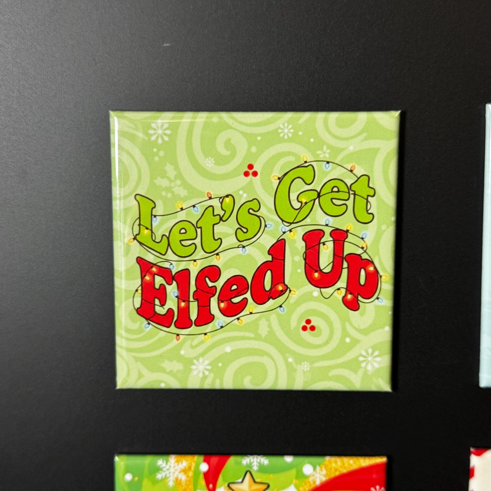 A square magnet with the text "Let's Get Elfed Up" on it, which appears to be a humorous Christmas-themed phrase.