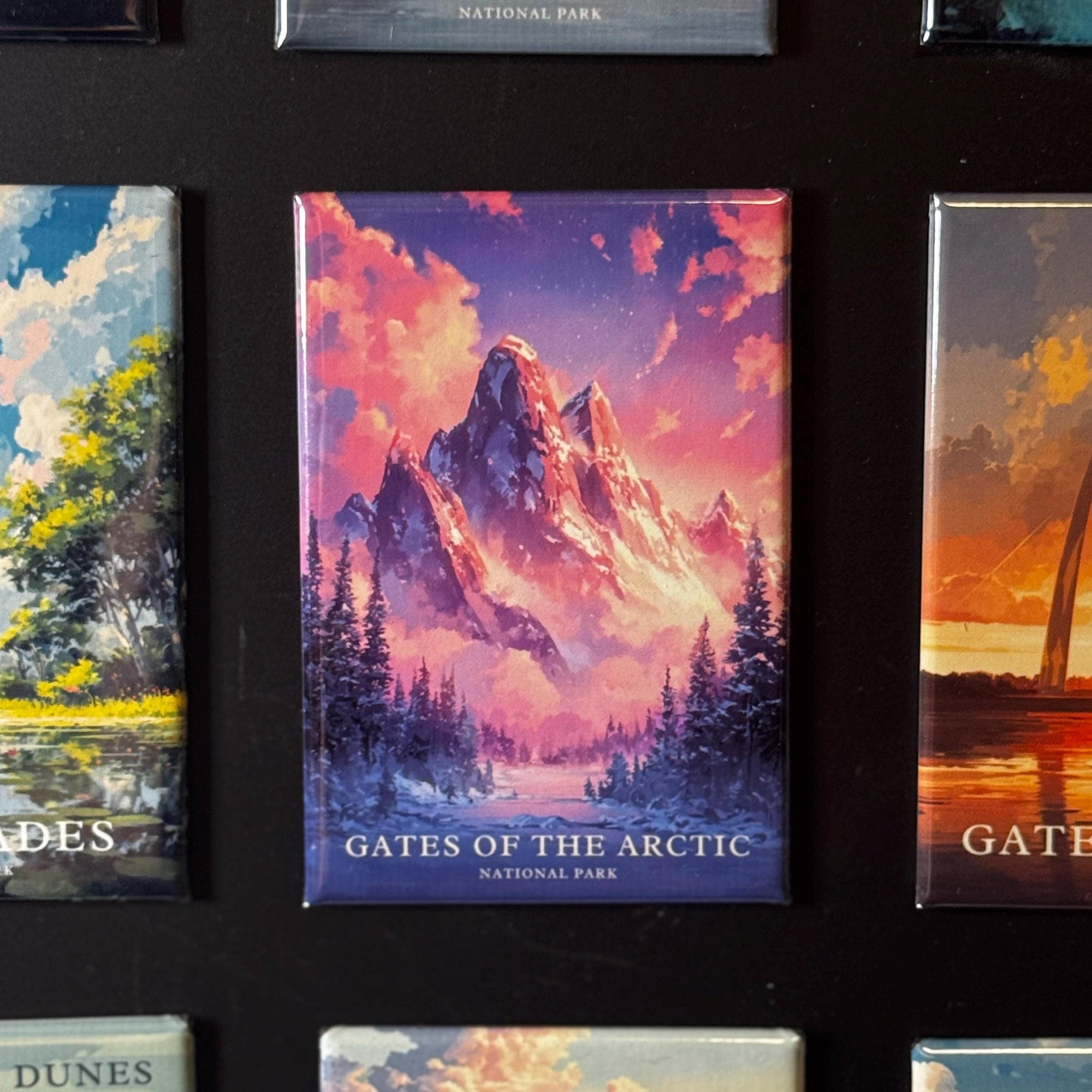 a collection of magnets depicting various landscapes, including a mountain range, a forest, and a body of water.