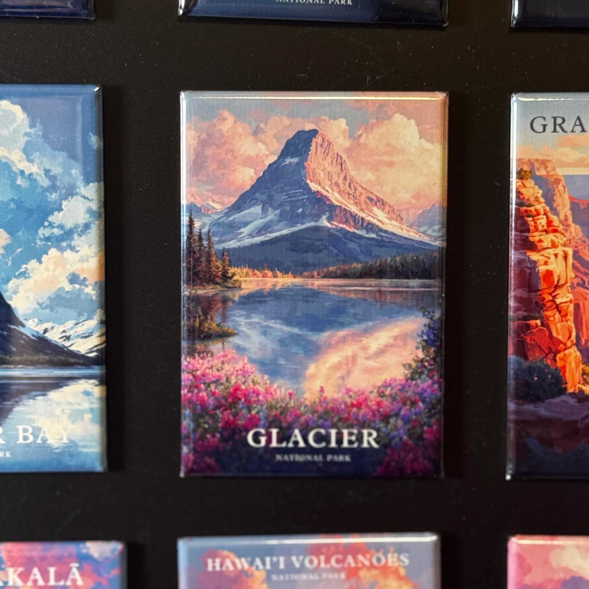 a collection of magnets depicting various natural landscapes, including mountains, lakes, and forests.