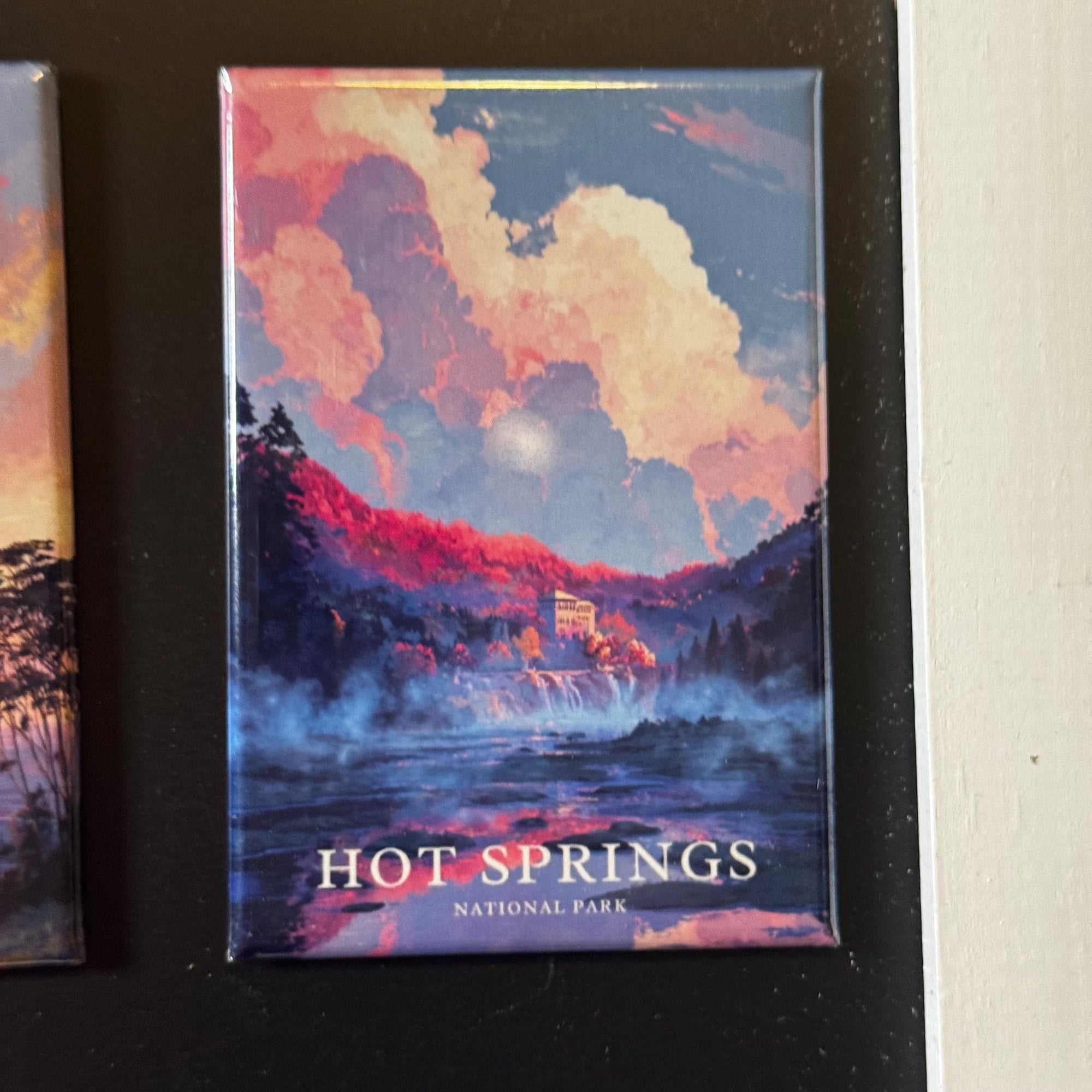 The image is a magnet depicting a scenic landscape with a waterfall and clouds, with the text "HOT SPRINGS NATIONAL PARK" below it.