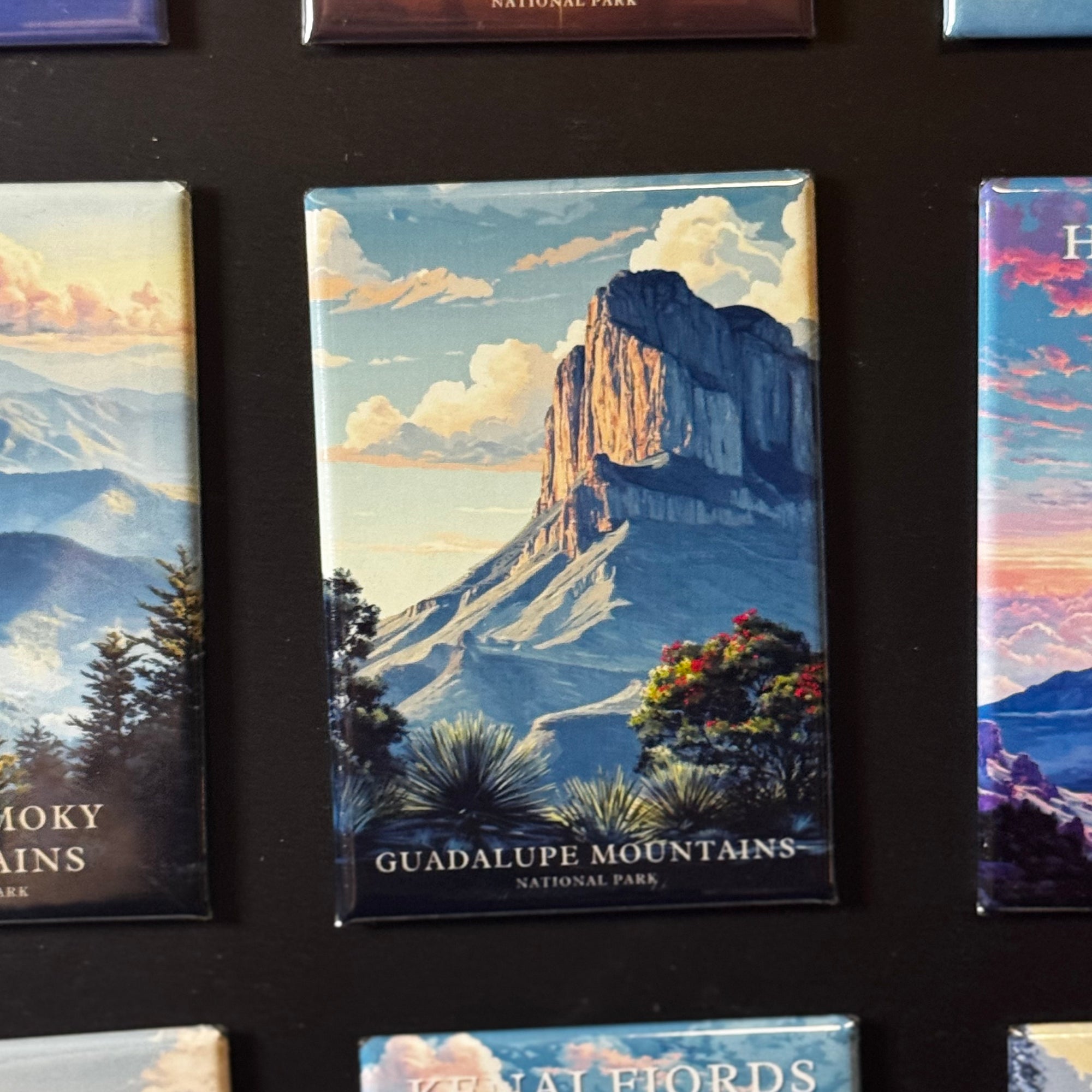 a collection of magnets depicting various scenic landscapes, including mountains, forests, and other natural features.